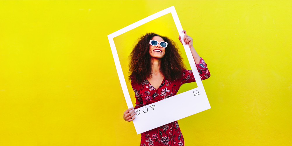 Woman posing with a Polaroid photo frame prop